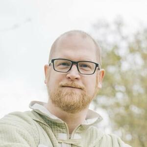 Imker D. Deutschmann auf der Wiese sitzend