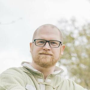 Imker D. Deutschmann auf der Wiese sitzend